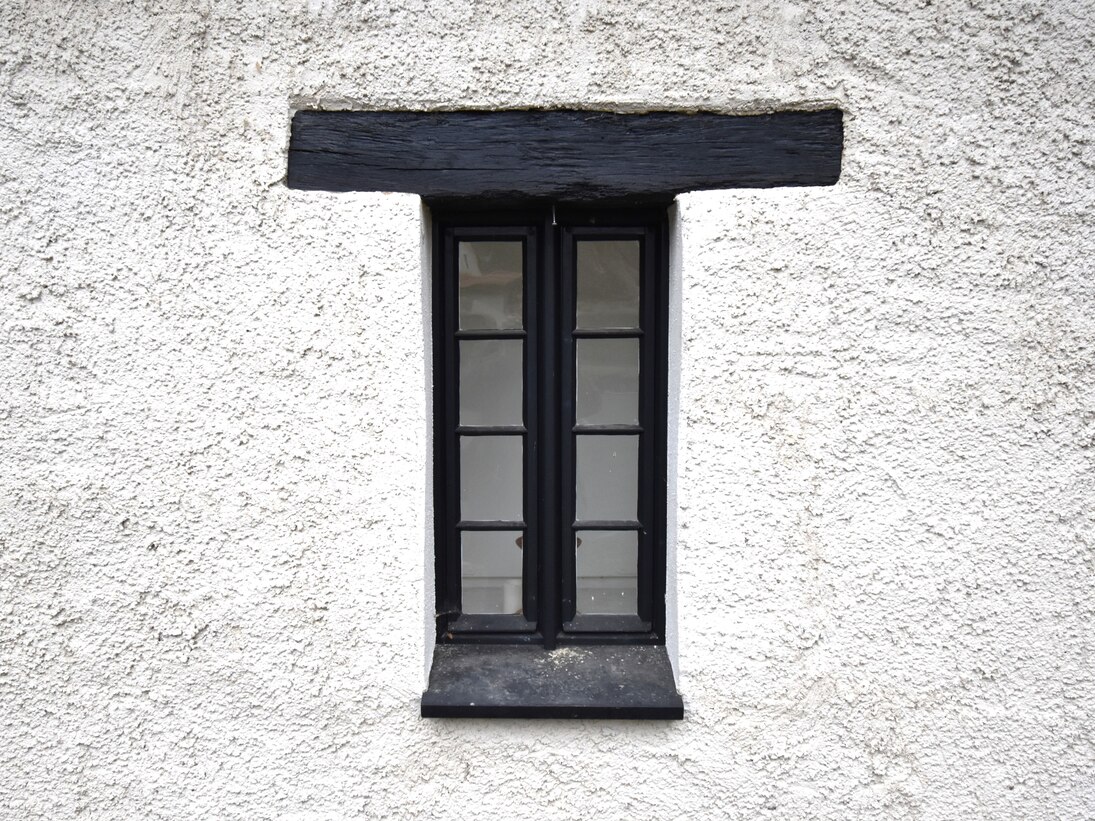 Ein schmales, hohes Fenster mit einem Fenstersturz aus Holz