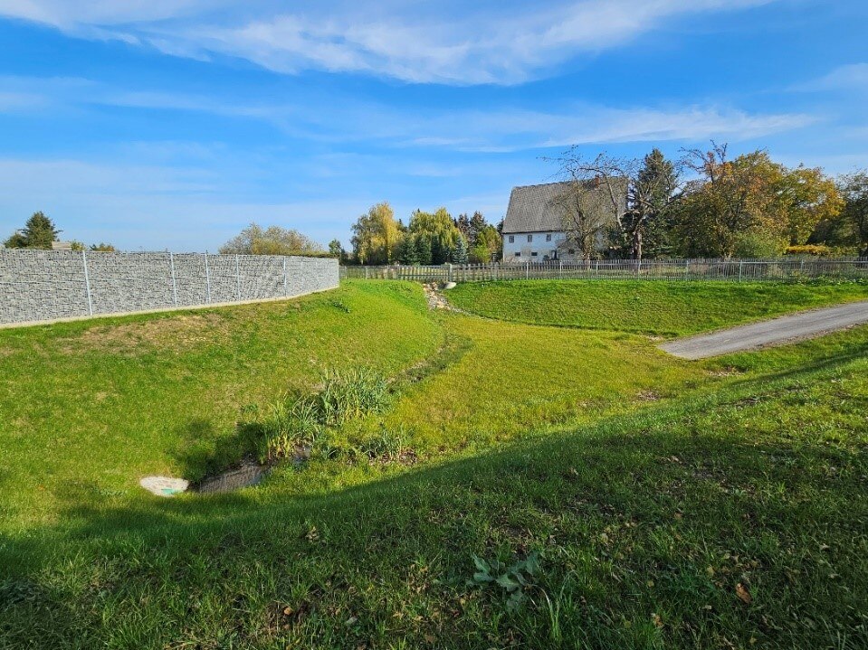 Blick auf das vergrößerte Rückhaltebecken mit Gabionenwand