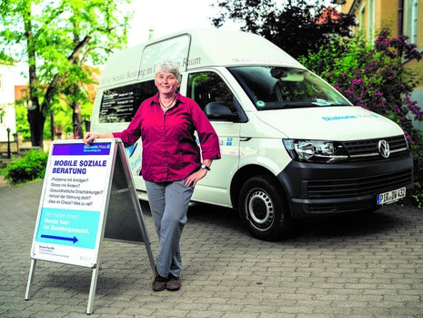 Sozialarbeiterin vor Transportfahrzeug